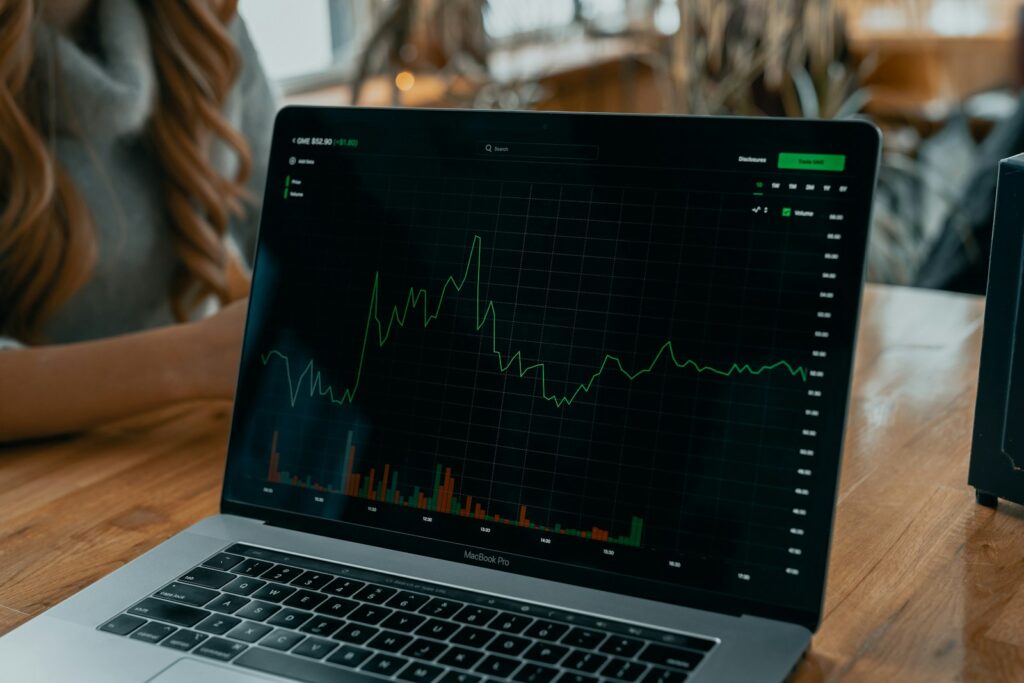Laptop showing a financial chart on a desk